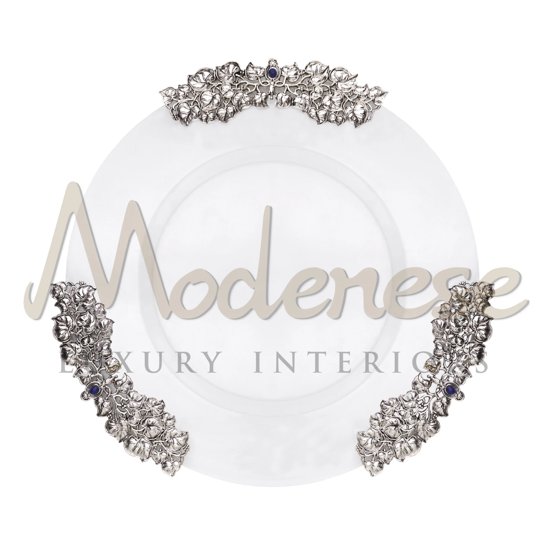 Decorative charger plate with silver floral pattern and embelished blue stones .