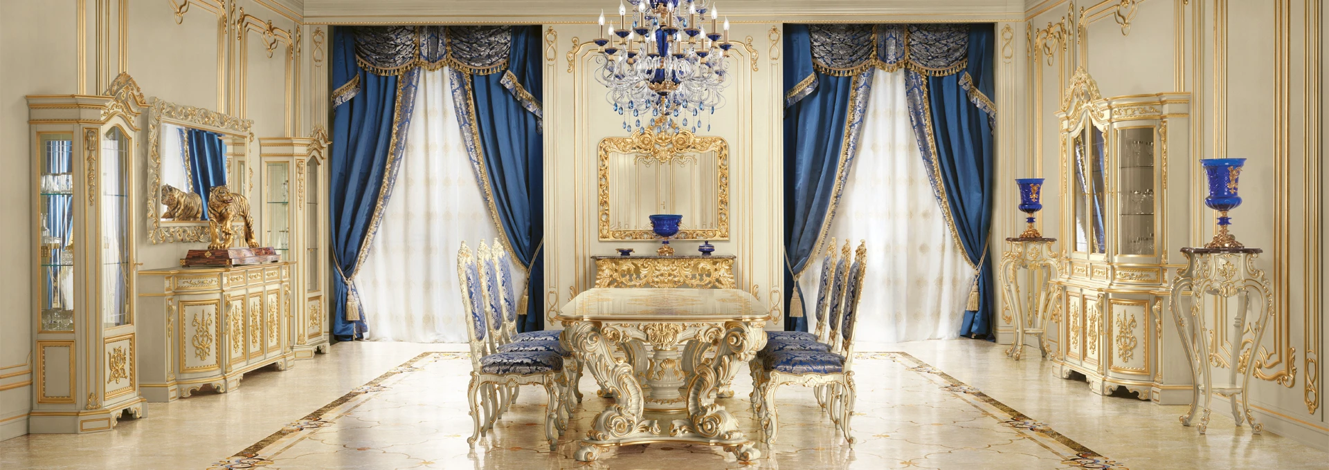 A sophisticated Heritage Dining room by Modenese Interiors, featuring an ornate gold and silver leaf table surrounded by classic chairs with vibrant, contemporary blue geometric fabric.