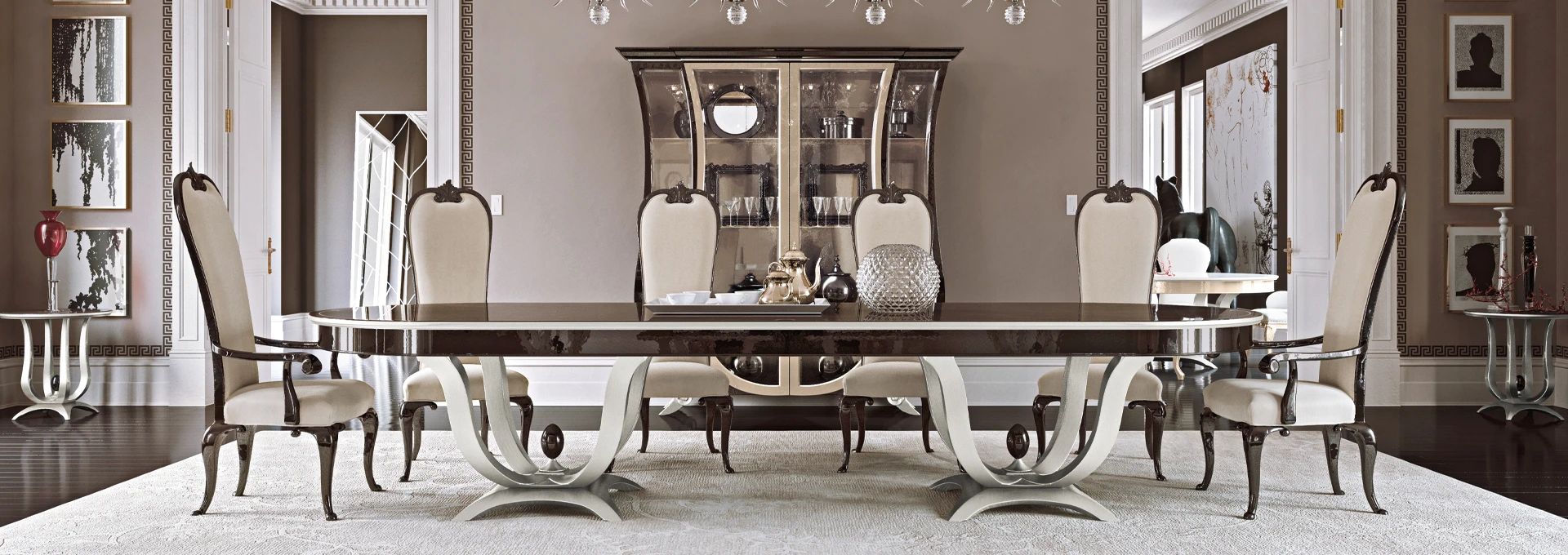 A luxurious prestige dining room setting by Modenese, featuring a long, high-gloss dark wood table surrounded by elegant cream upholstered chairs with classic curved backs.
