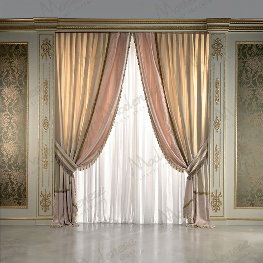A pair of h140 sheer curtains by SARELLI with delicate lace and Swarovski decorations hanging gracefully in a grand, sunlit window.