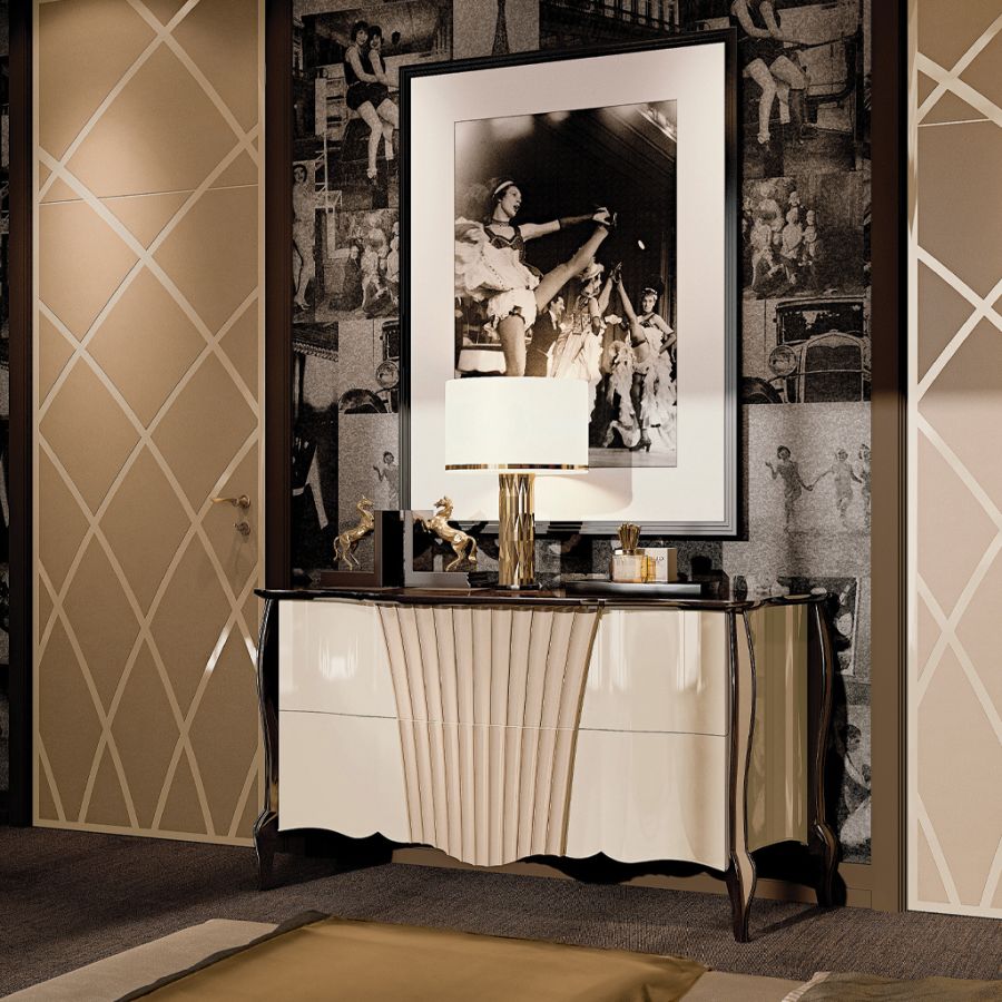 An elegant teal velvet armchair creates a vibrant accent in a unique bedroom, placed beside a contemporary side table crafted from rich Makassar wood.