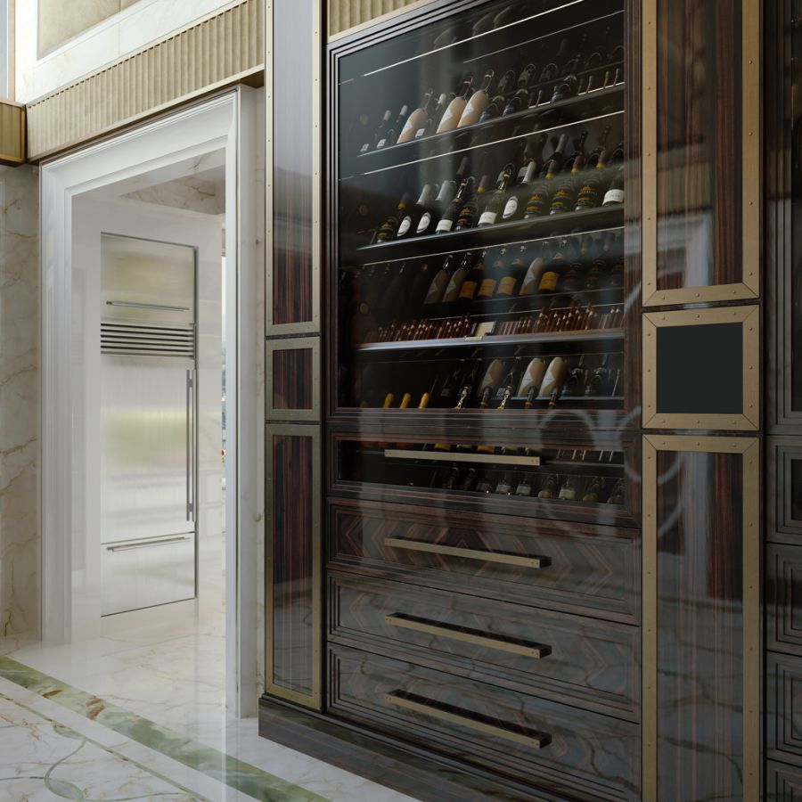 Two guests admiring the Modenese Projects EVOLUTION rotating champagne display during an evening gathering in a sophisticated penthouse dining room.